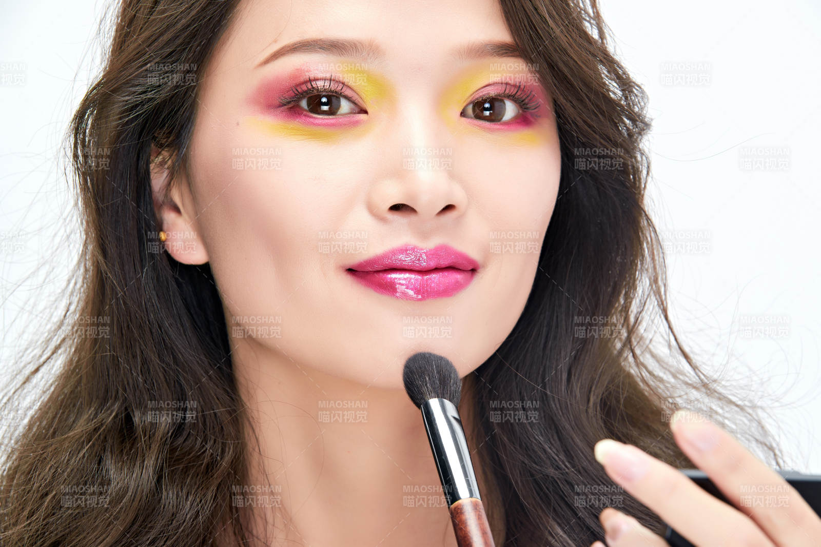 白色背景下棚拍化妝中的美女