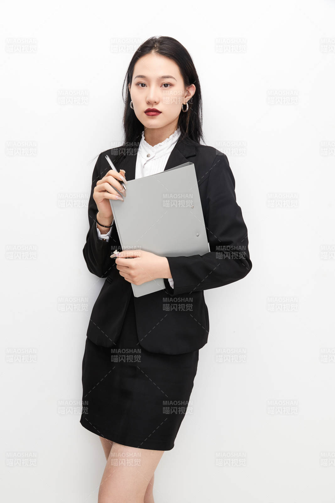 身穿西服拿著文件夾的美麗商務女士