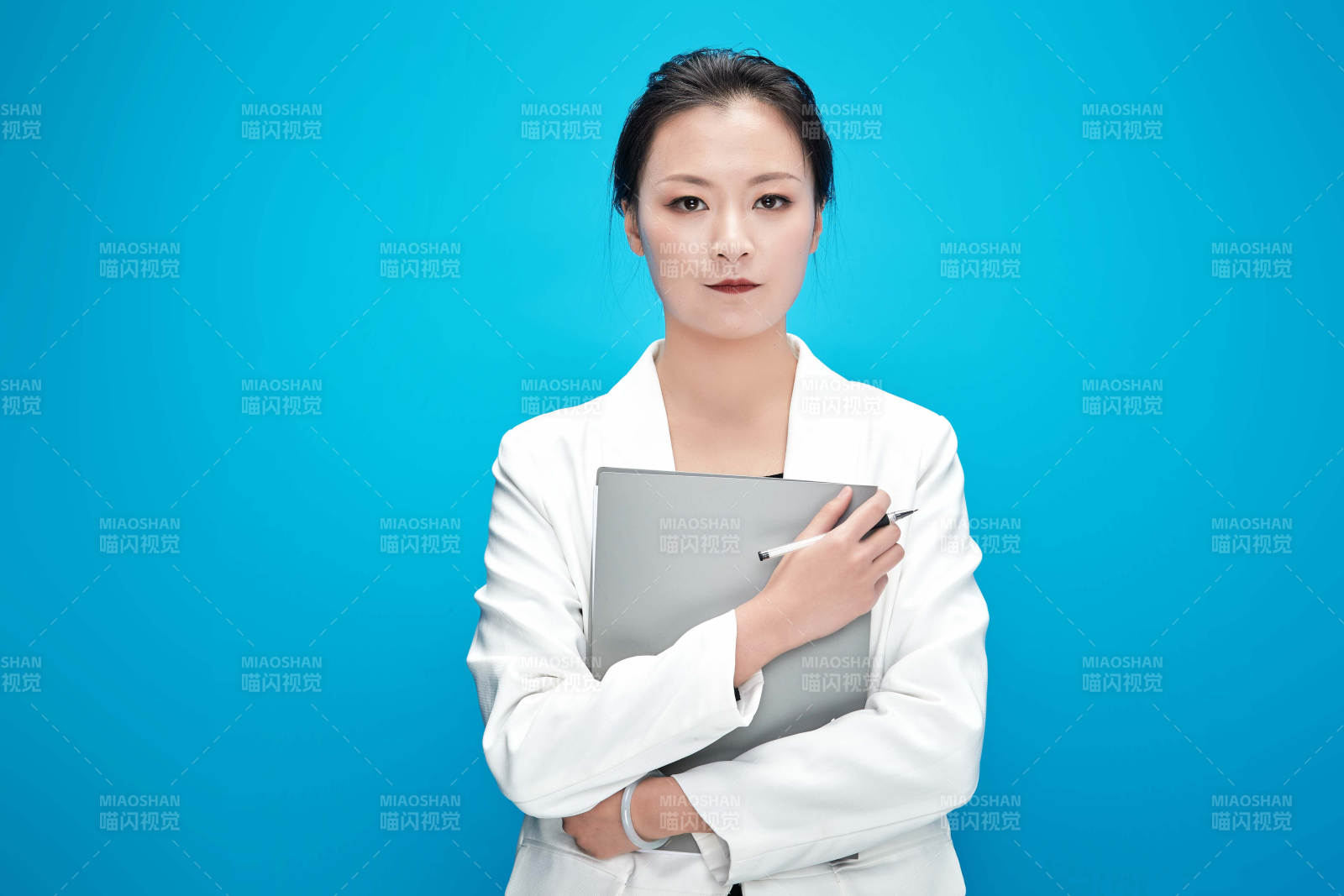 身穿西服拿著手機與文件夾的亞洲商務女士