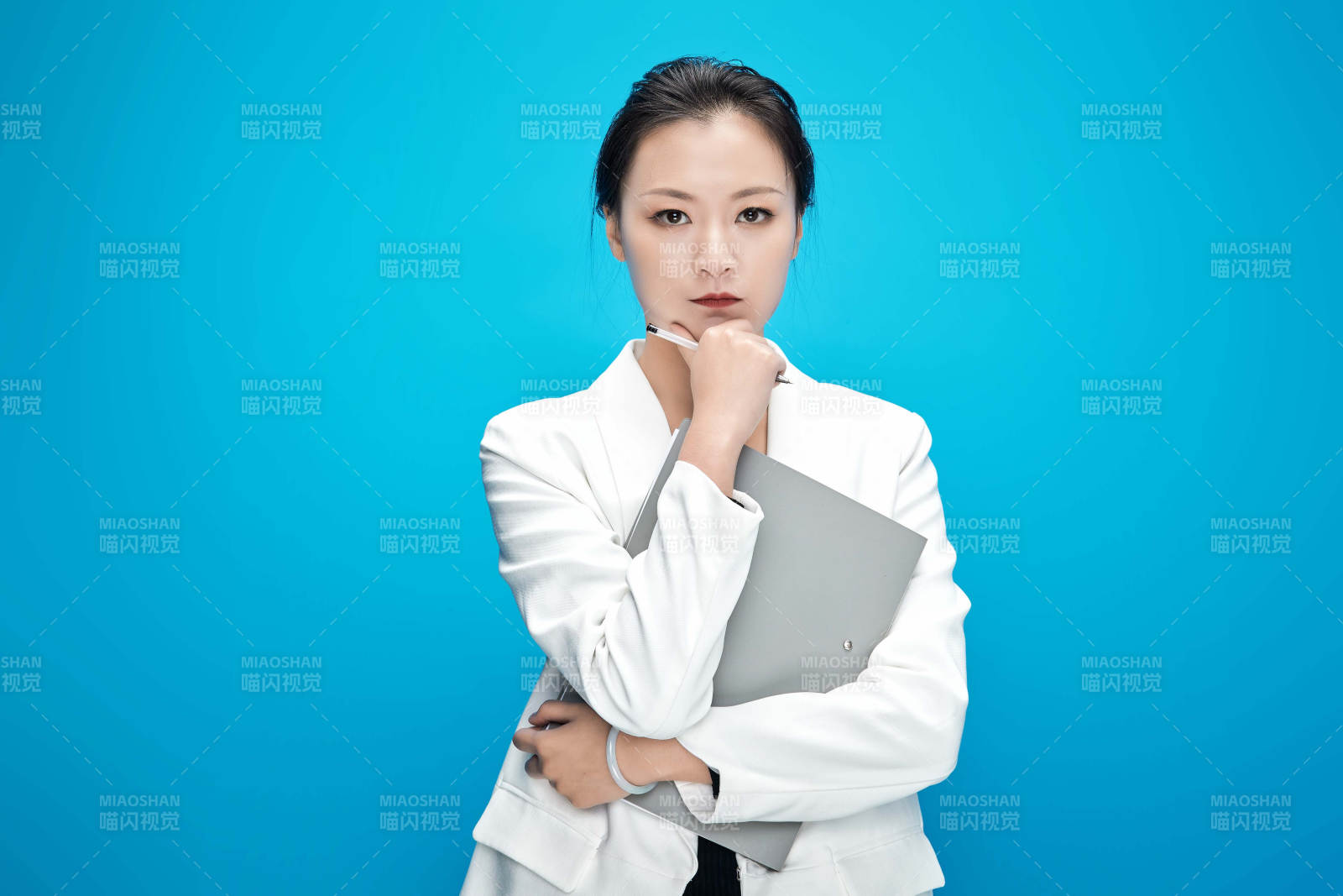 身穿西服拿著手機與文件夾的亞洲商務女士