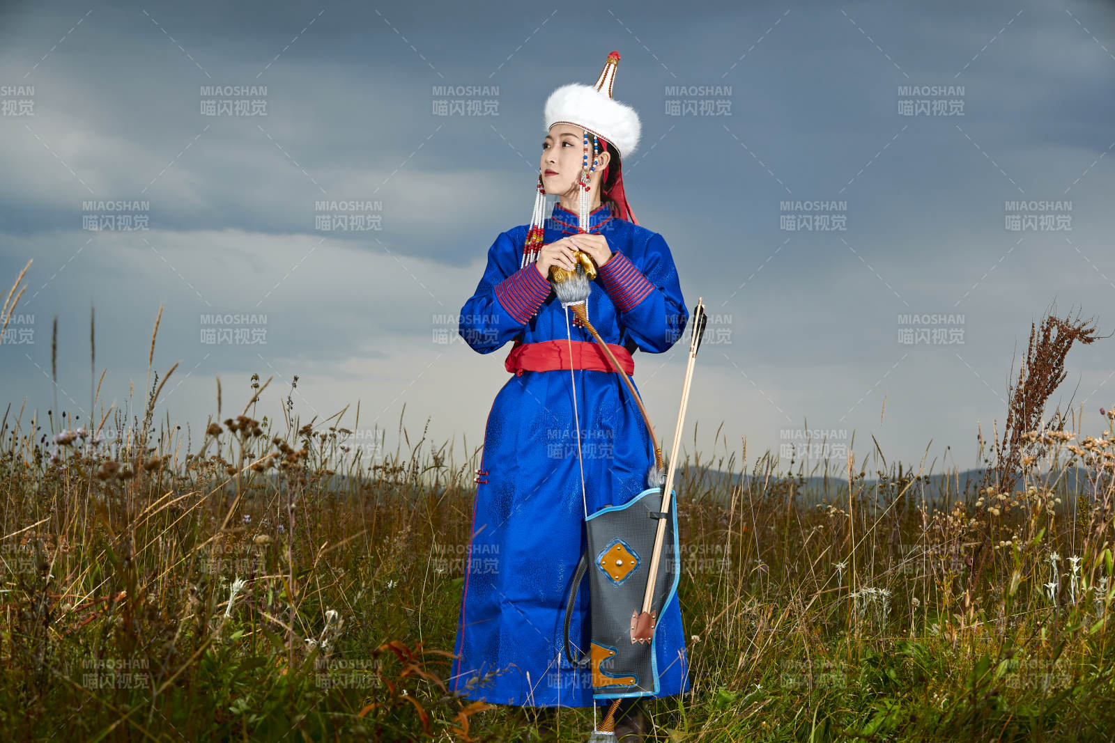 草原湖畔身穿蒙古族飾手持弓箭的蒙族少女