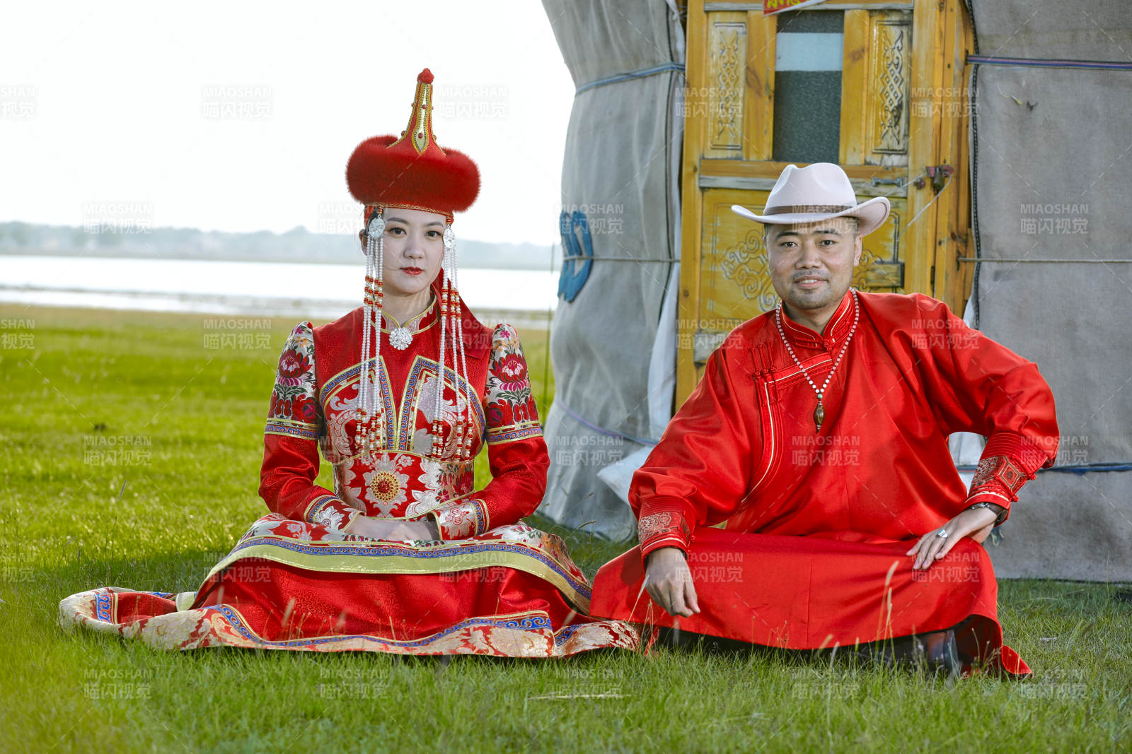 草原上蒙古包前穿蒙古族傳統(tǒng)服飾的年輕夫妻