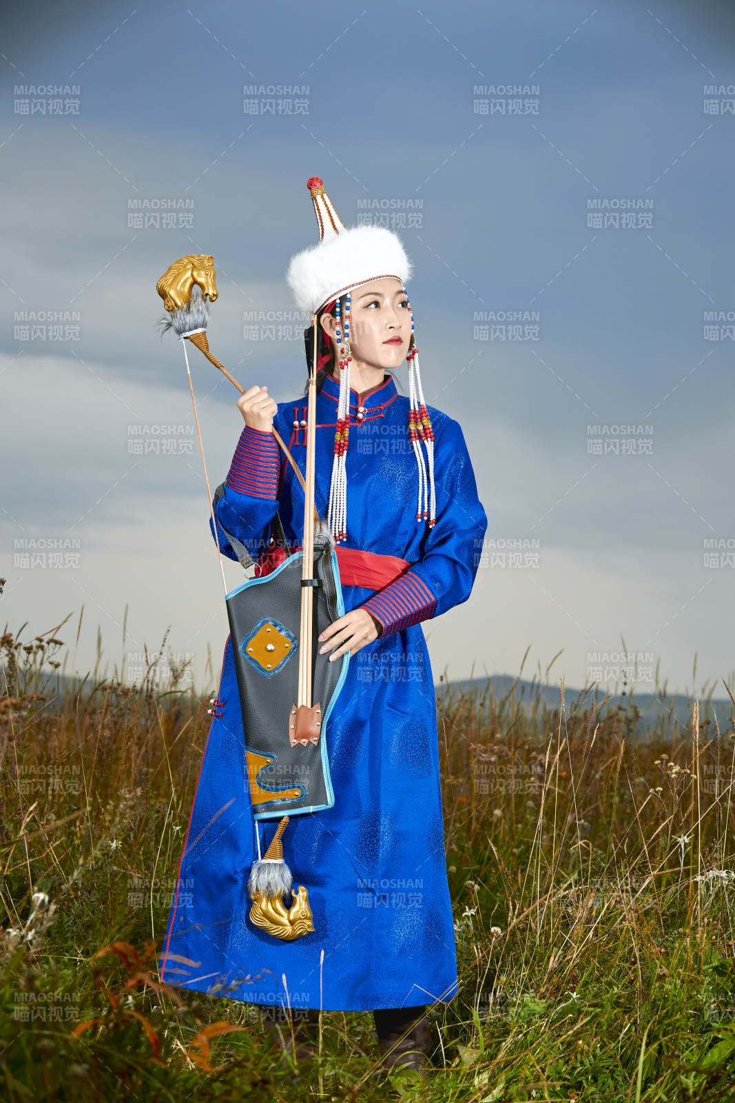 草原湖畔身穿蒙古族飾手持弓箭的蒙族少女