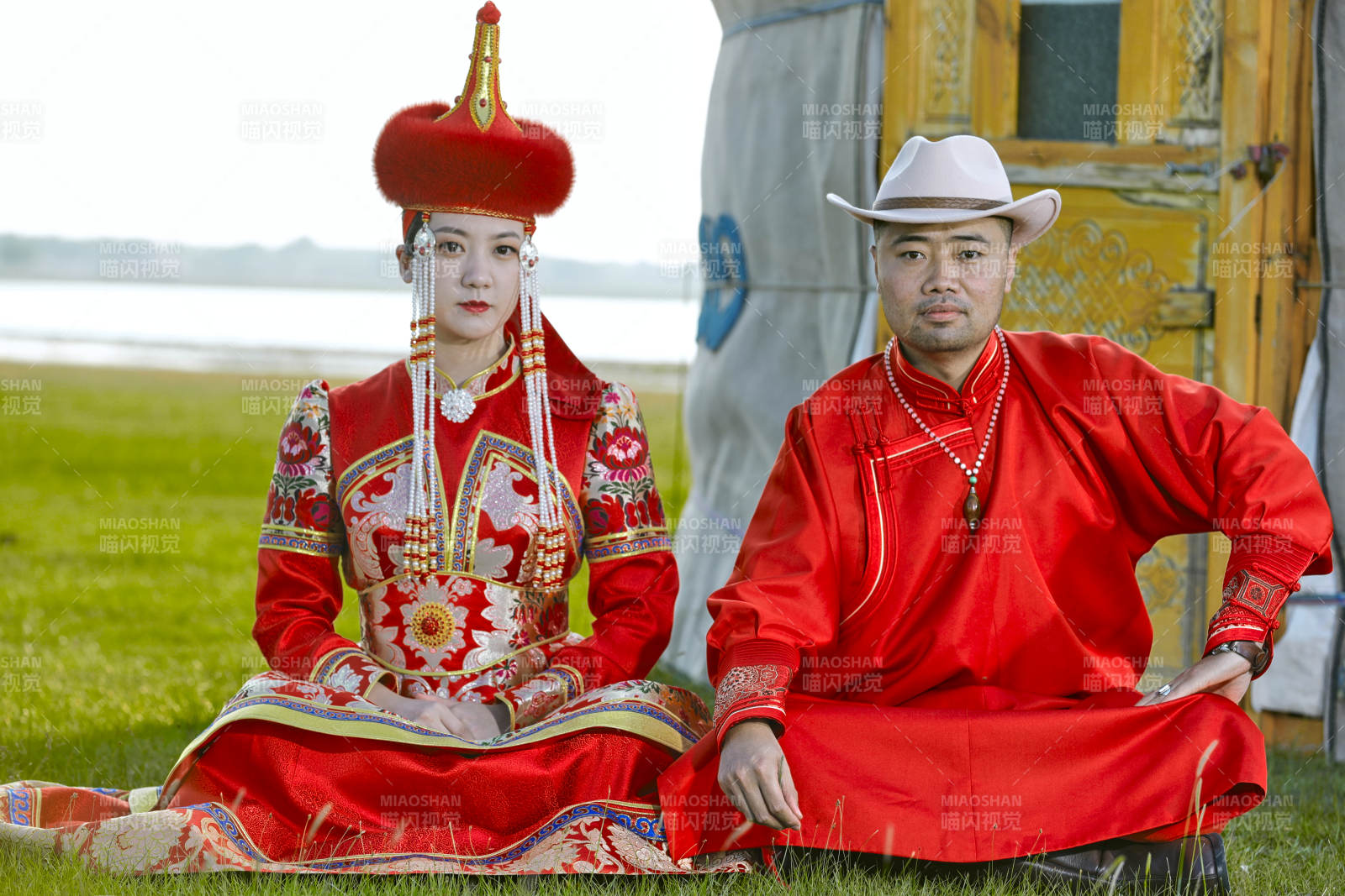 草原上蒙古包前穿蒙古族傳統服飾的年輕夫妻