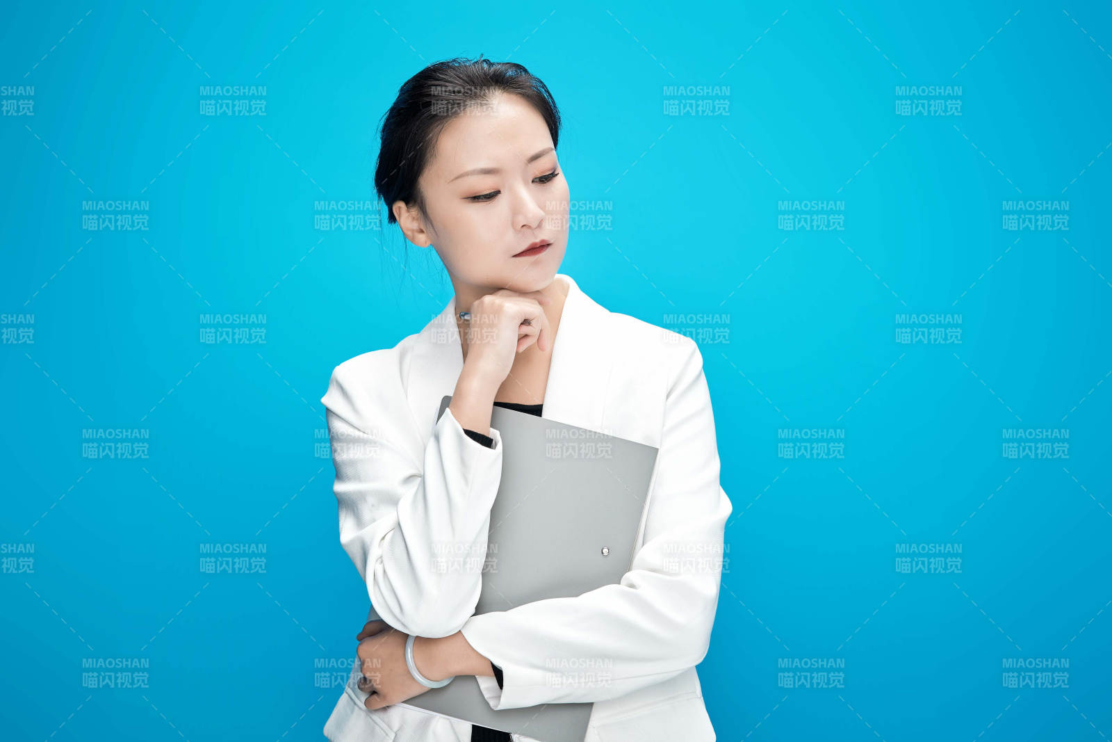 身穿西服拿着手机与文件夹的亚洲商务女士