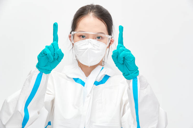 穿白色防护服佩戴护目镜口罩的女性医疗人员