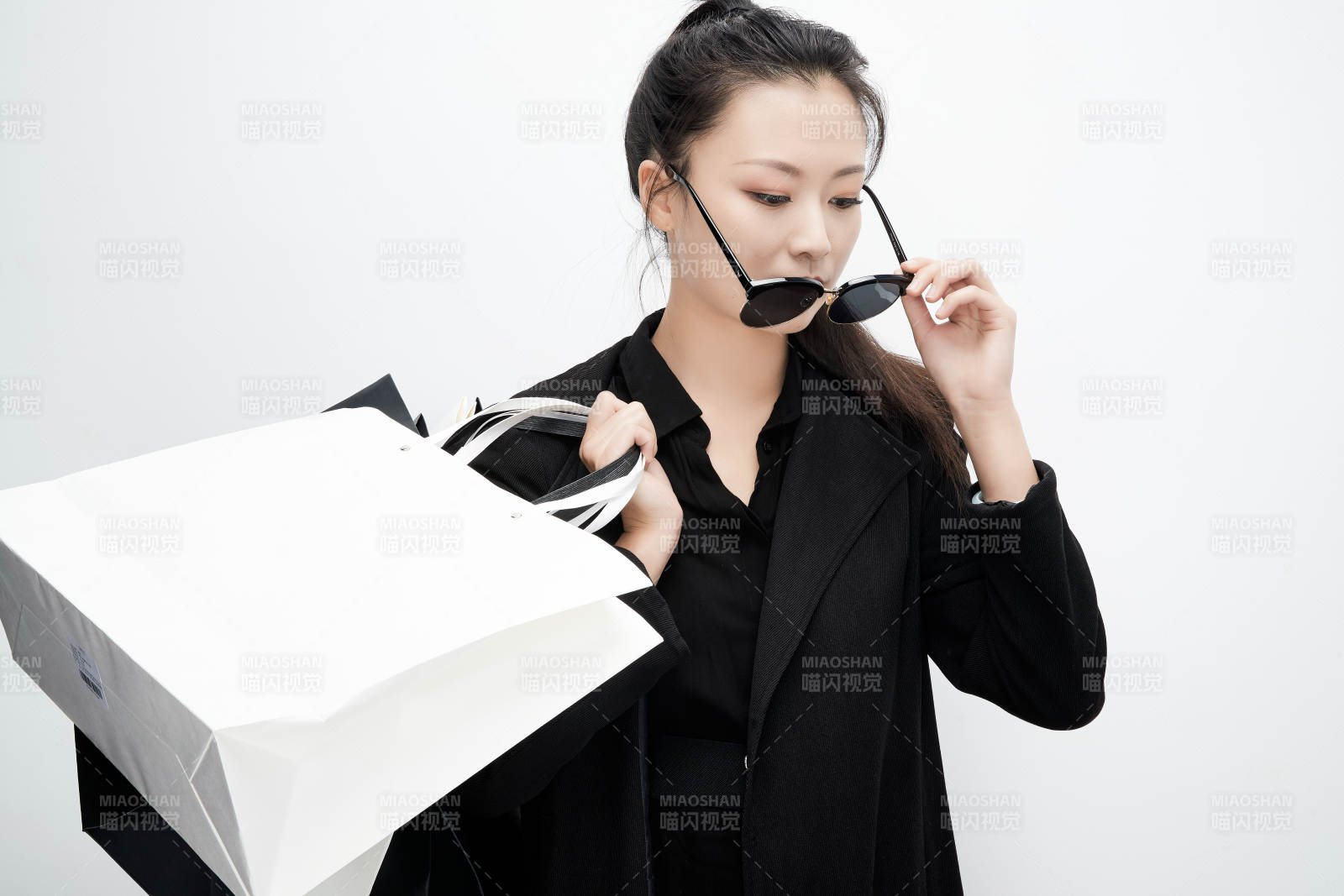 白色背景下手提購(gòu)物袋時(shí)尚美麗的亞洲少女