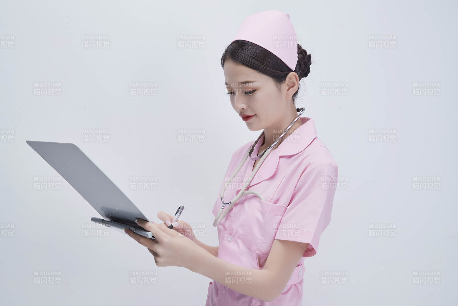 穿粉色護士服戴聽診器手持病歷夾的醫護人員