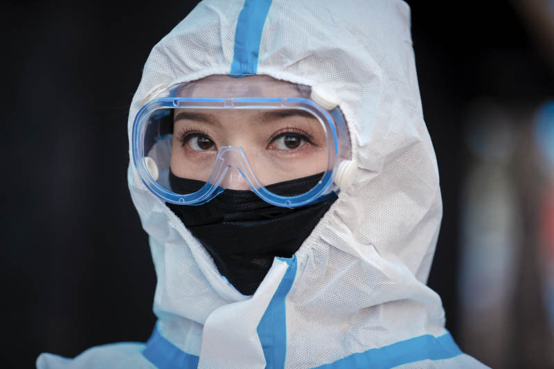 穿白色防护服佩戴护目镜口罩的女性防护人员