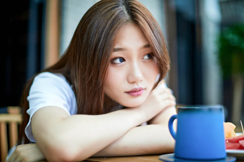 坐在咖啡图书馆吃东西的可爱少女