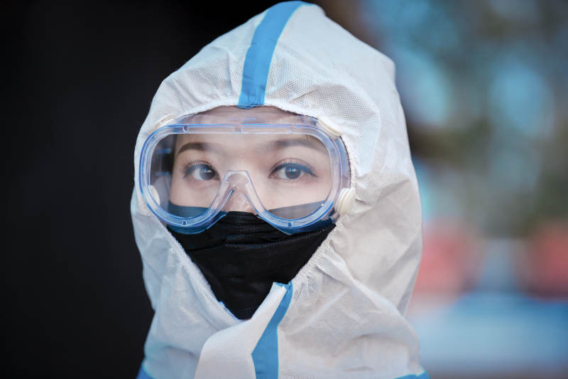穿白色防护服佩戴护目镜口罩的女性防护人员