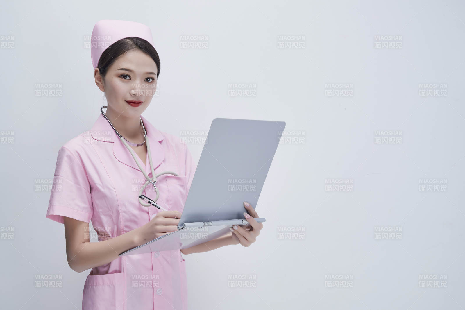 穿粉色護士服戴聽診器手持病歷夾的醫護人員
