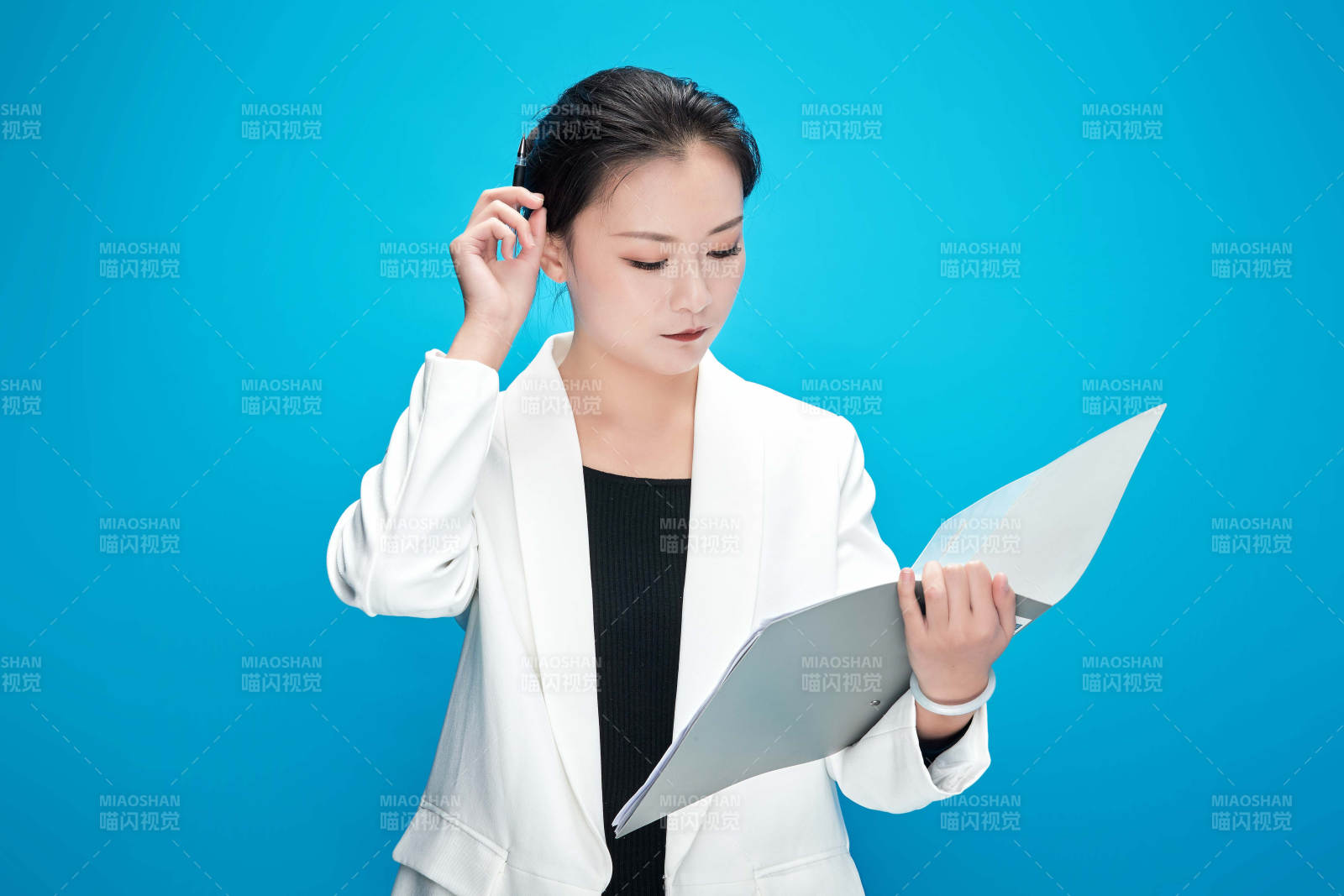 身穿西服拿著手機與文件夾的亞洲商務女士