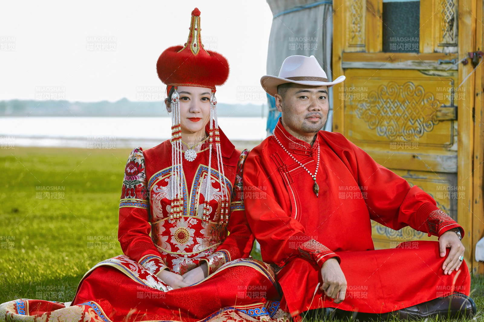 草原上蒙古包前穿蒙古族傳統服飾的年輕夫妻