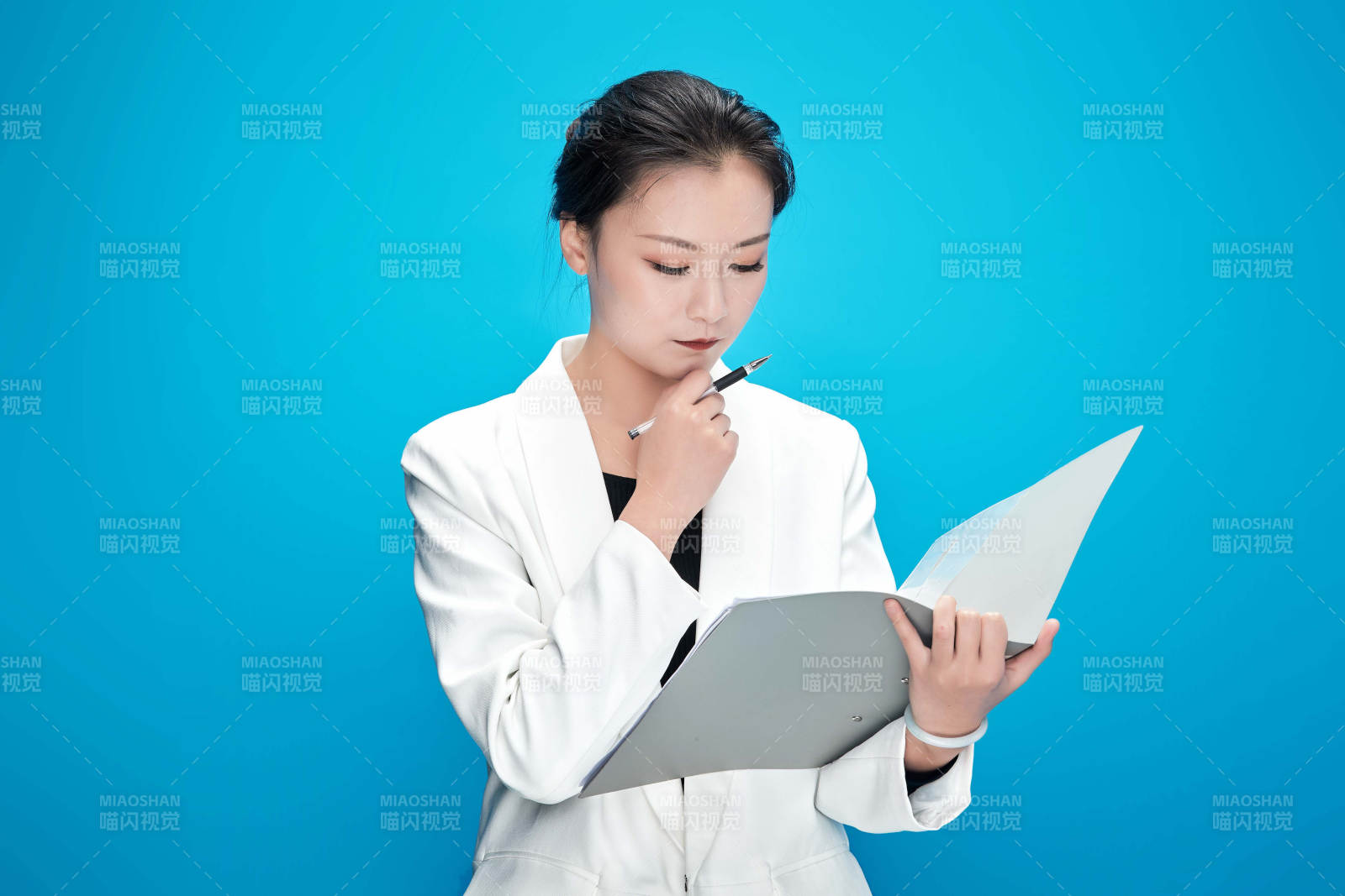 身穿西服拿著手機與文件夾的亞洲商務女士