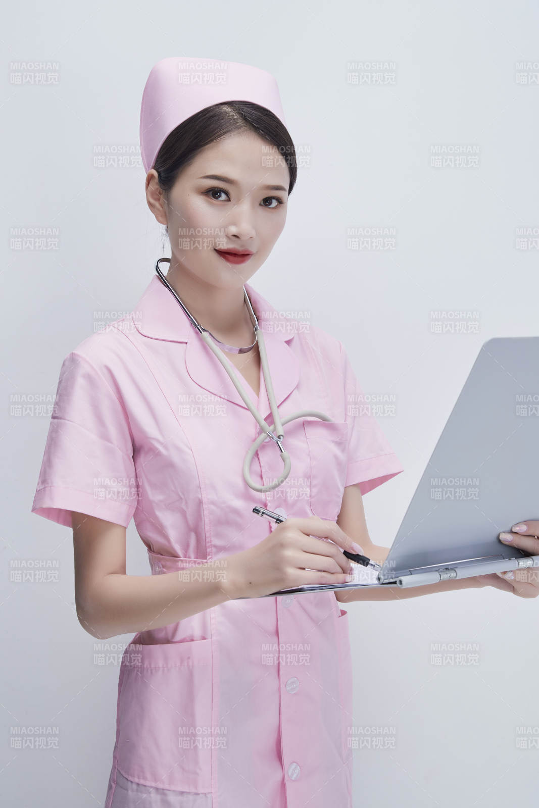 穿粉色護士服戴聽診器手持病歷夾的醫護人員