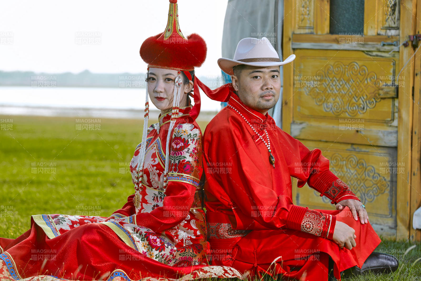 草原上蒙古包前穿蒙古族傳統服飾的年輕夫妻