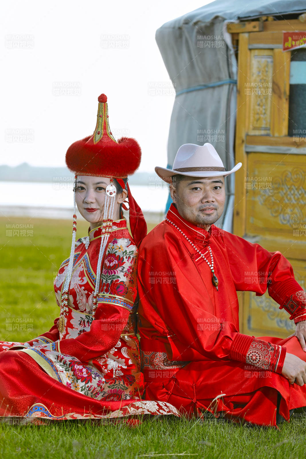 草原上蒙古包前穿蒙古族傳統服飾的年輕夫妻