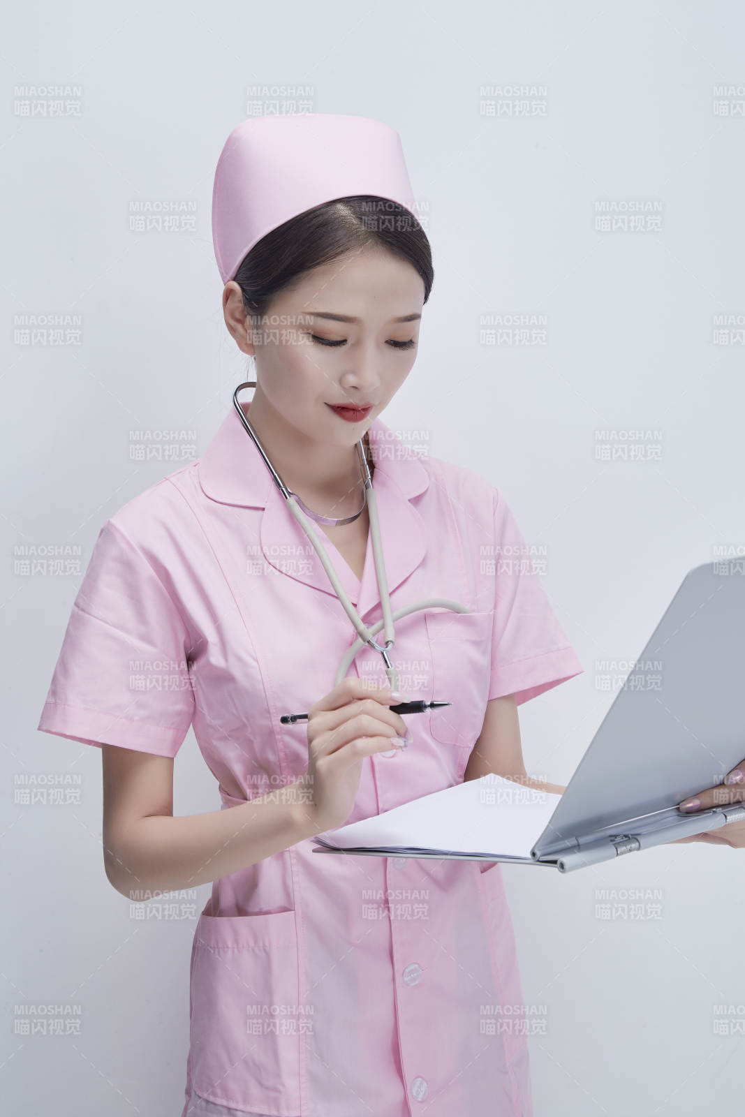 穿粉色護士服戴聽診器手持病歷夾的醫護人員