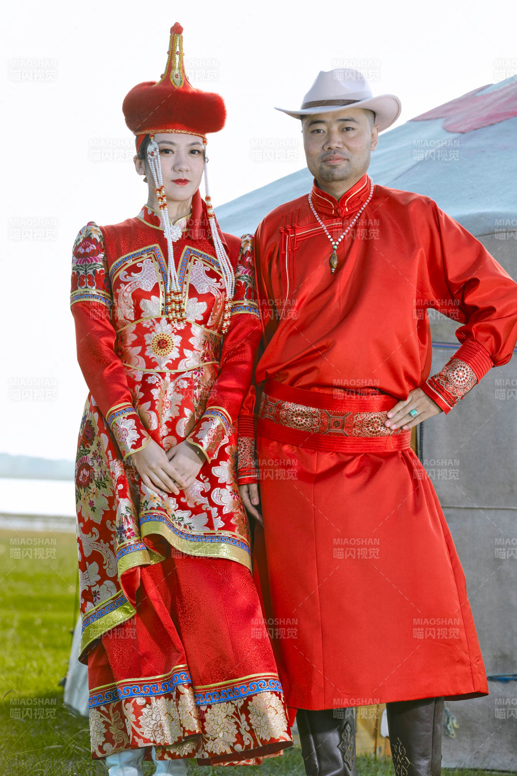 草原上蒙古包前穿蒙古族傳統(tǒng)服飾的年輕夫妻