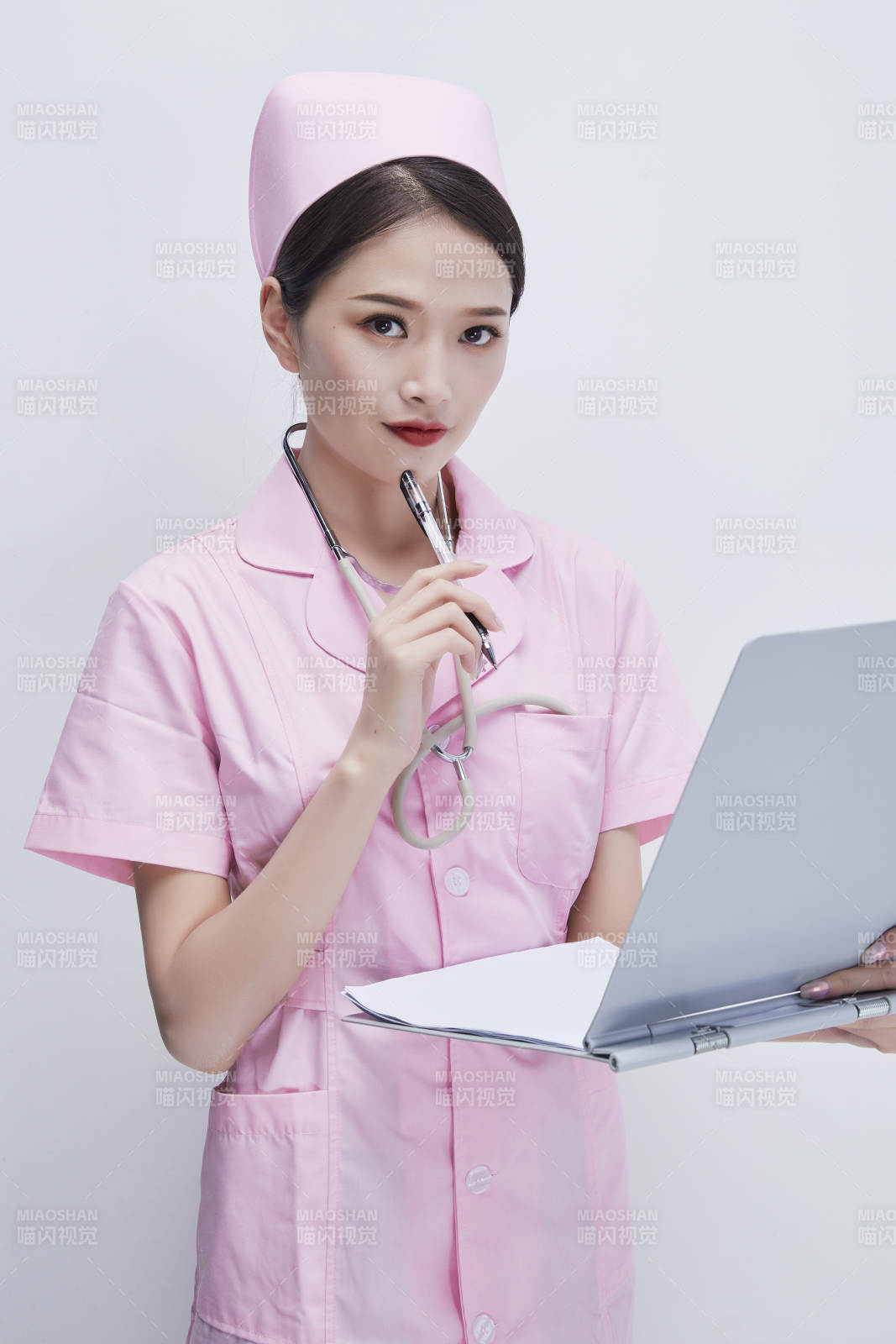 穿粉色護士服戴聽診器手持病歷夾的醫護人員