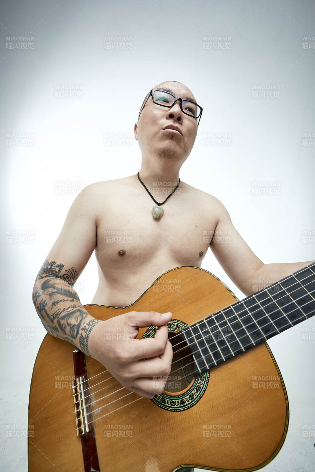 示范演奏古典吉他的亞洲男性樂手人像