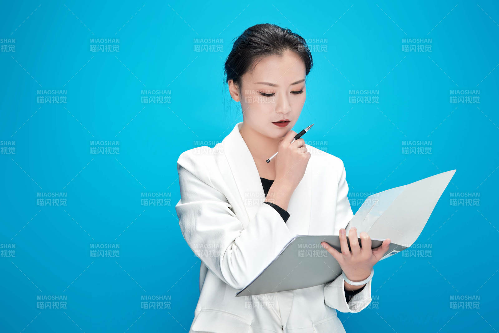 身穿西服拿著手機(jī)與文件夾的亞洲商務(wù)女士