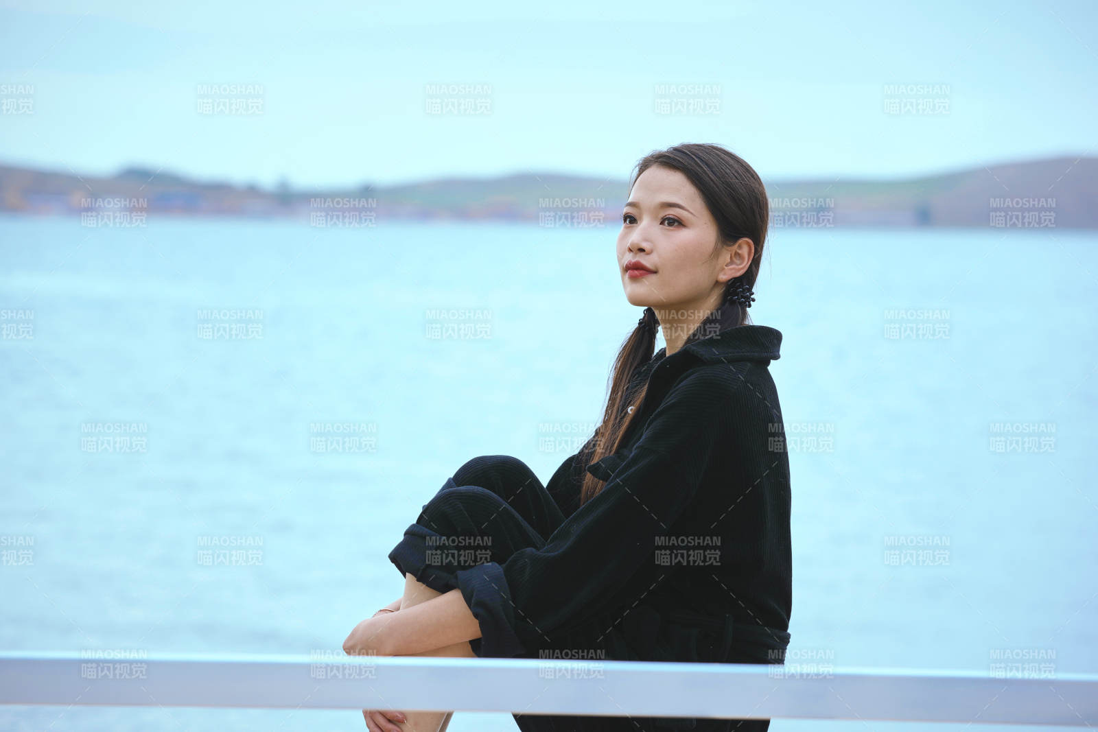 悠閑的坐在美麗湖岸碼頭的亞洲年輕女性人像