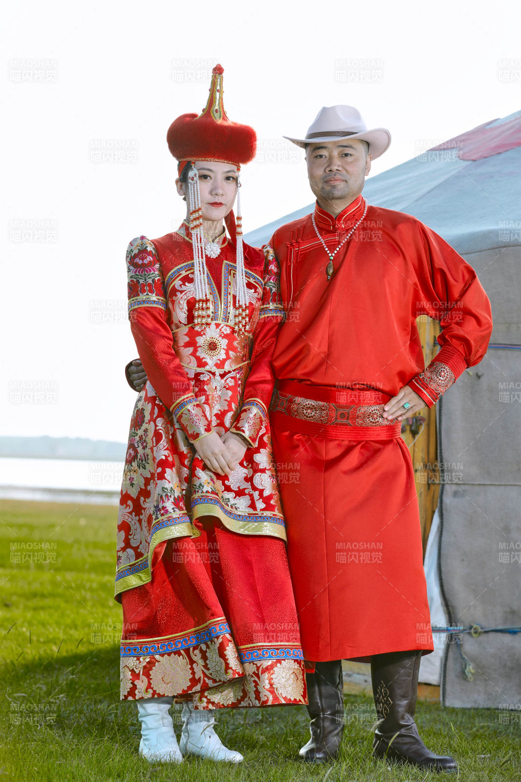 草原上蒙古包前穿蒙古族傳統(tǒng)服飾的年輕夫妻