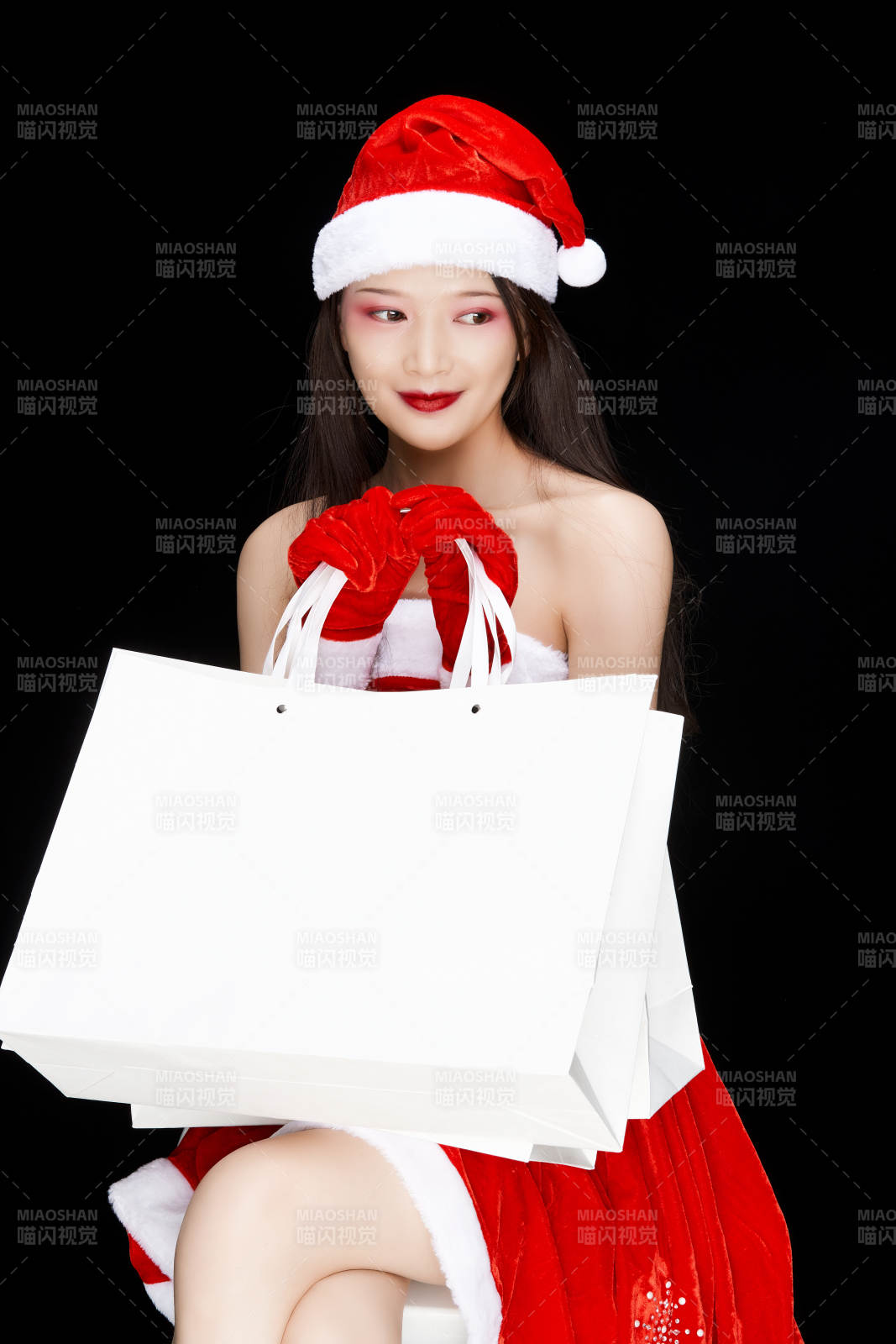 身穿圣誕服飾手提購物袋性感可愛的圣誕女郎