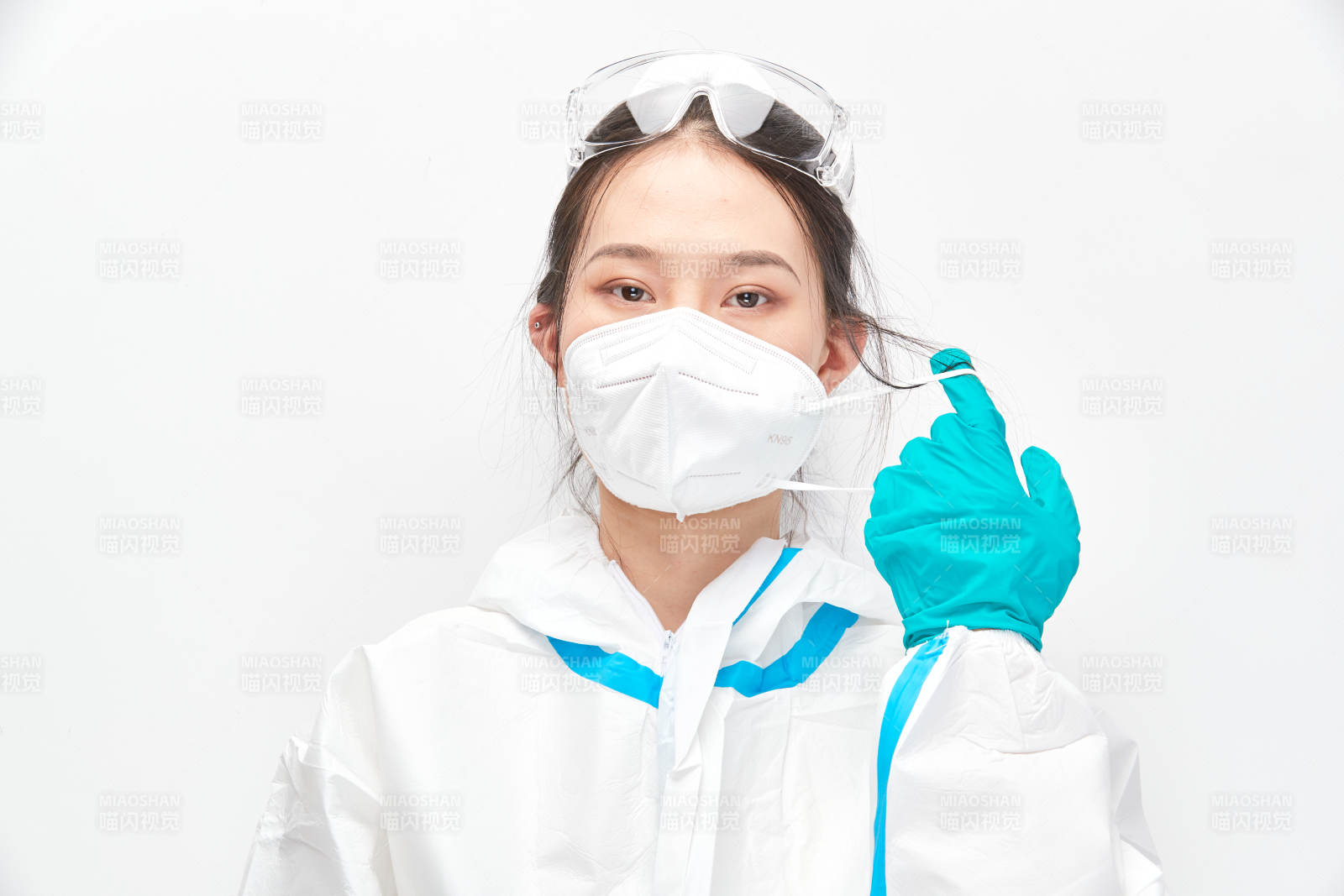 穿白色防護(hù)服佩戴護(hù)目鏡口罩的女性醫(yī)療人員