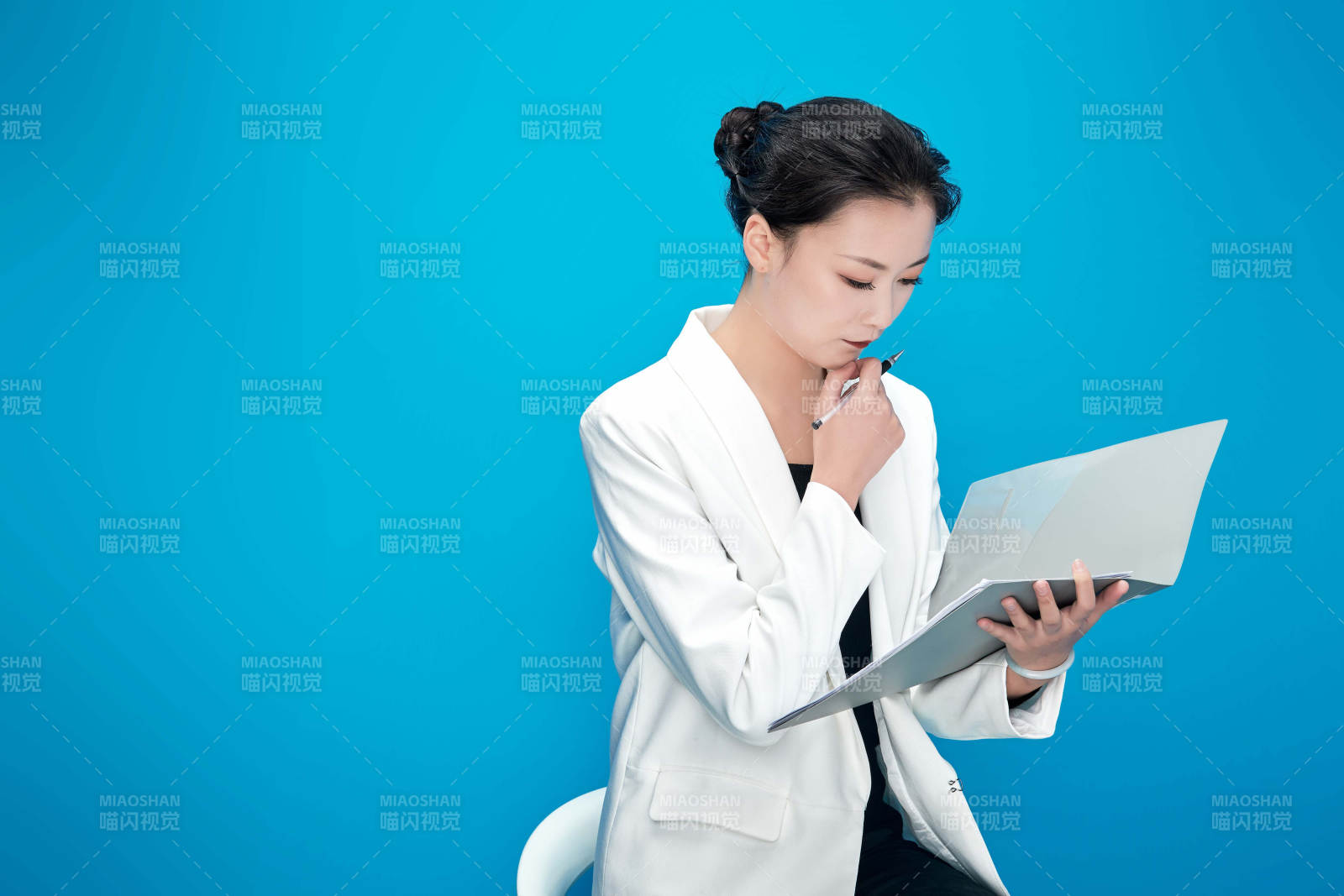 身穿西服拿著手機與文件夾的亞洲商務女士