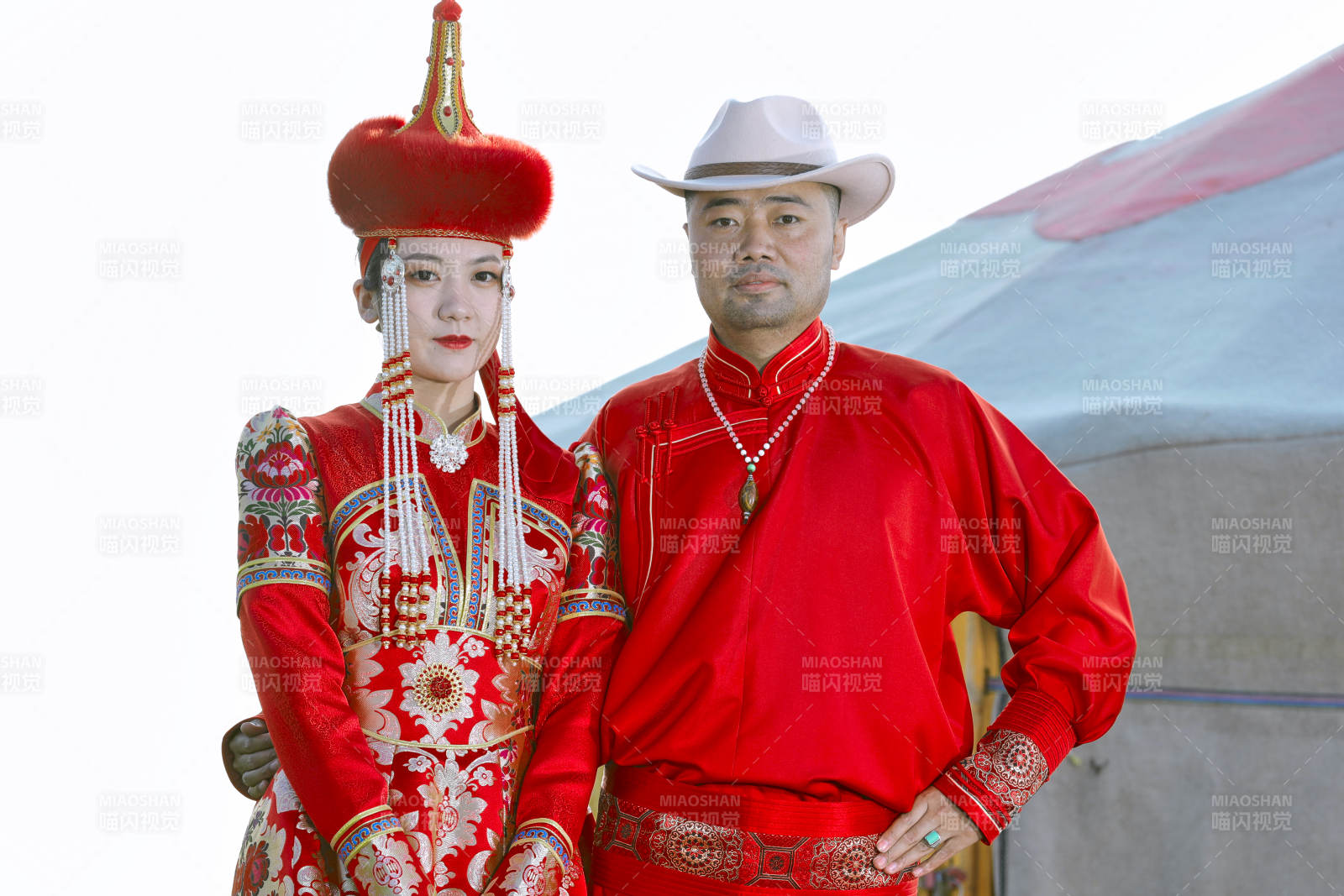 草原上蒙古包前穿蒙古族傳統服飾的年輕夫妻