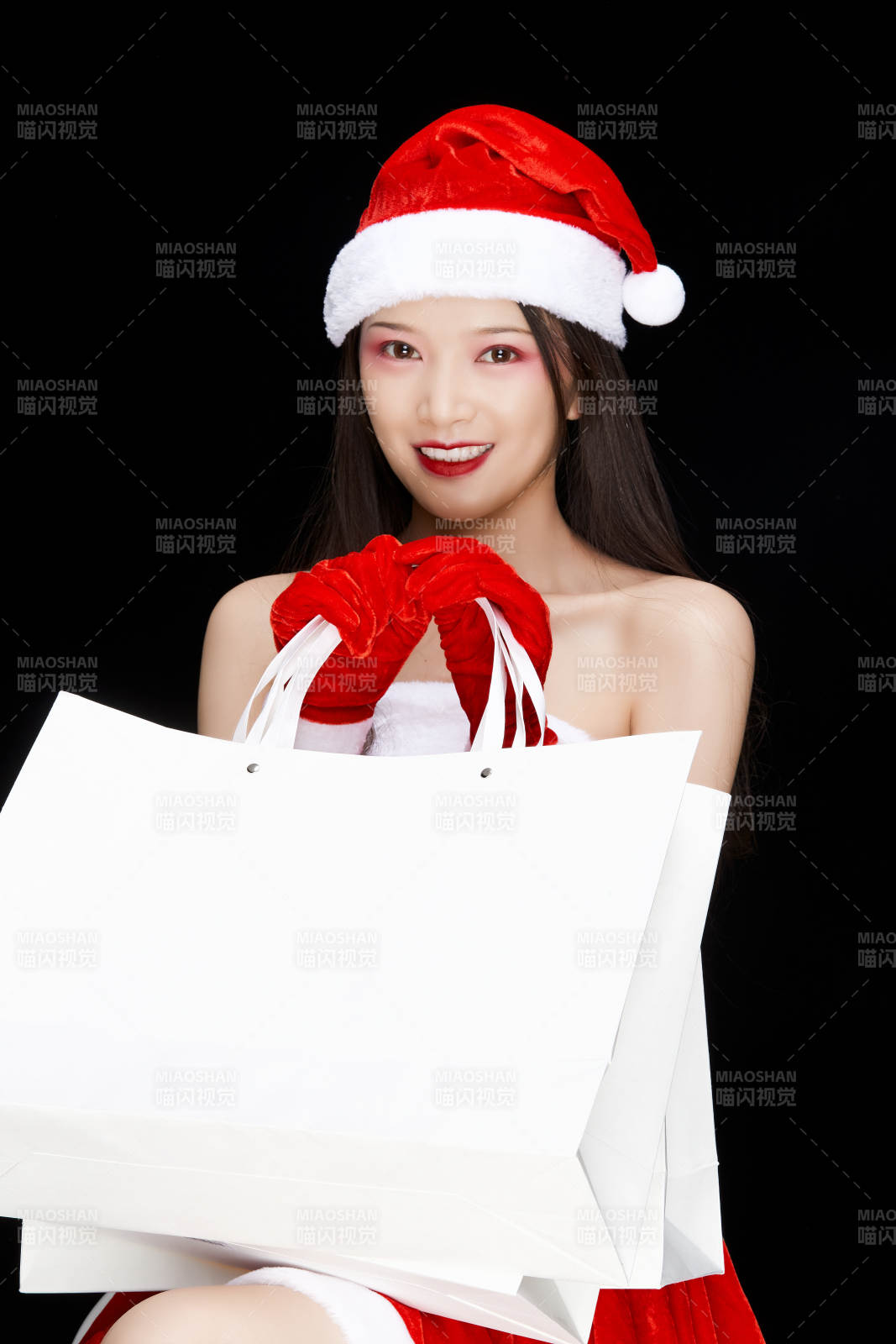 身穿圣誕服飾手提購物袋性感可愛的圣誕女郎