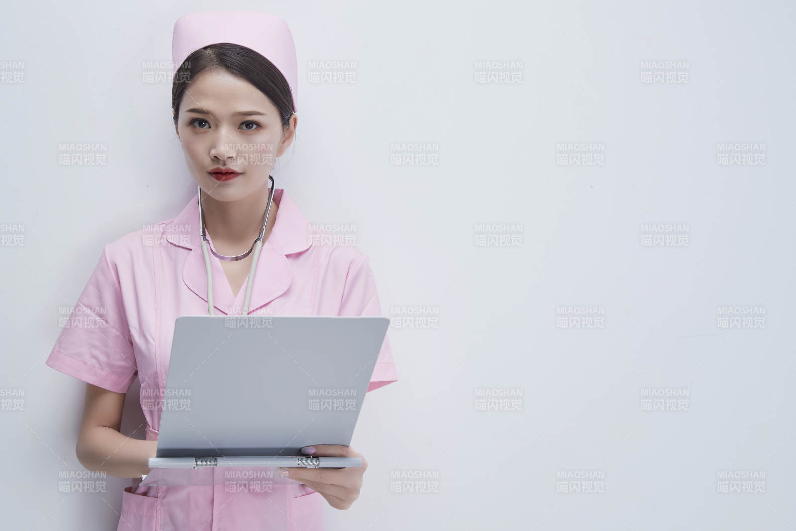 穿粉色護士服戴聽診器手持病歷夾的醫護人員