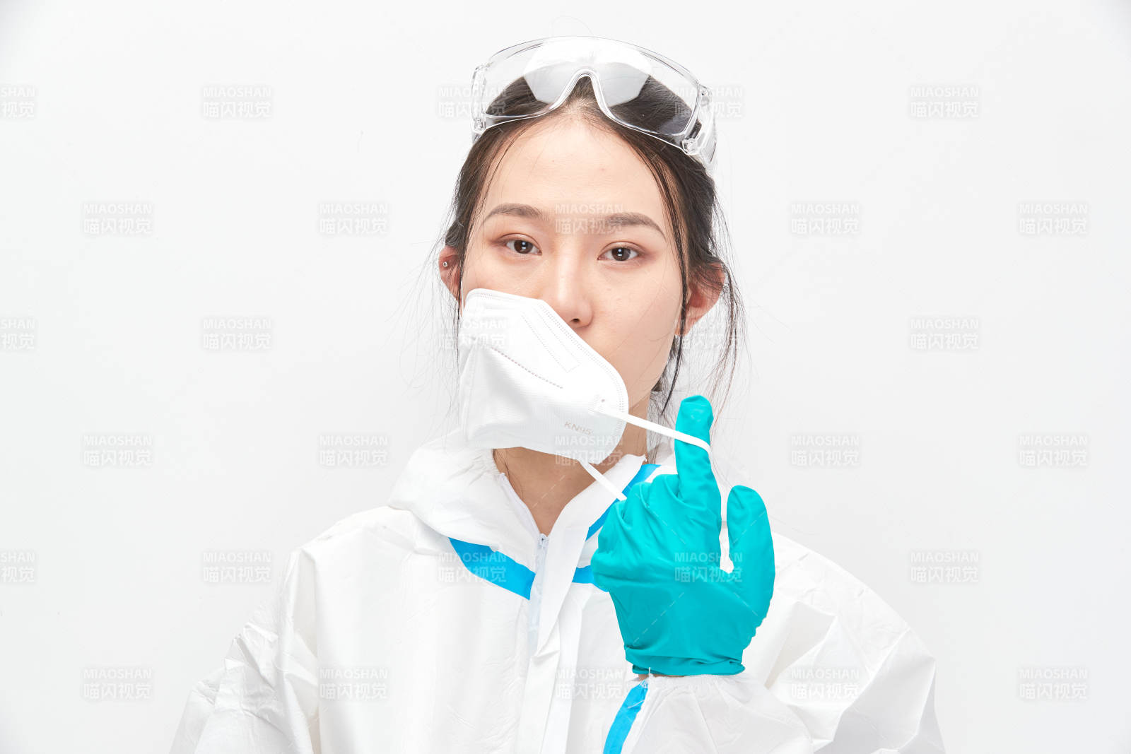 穿白色防護服佩戴護目鏡口罩的女性醫(yī)療人員