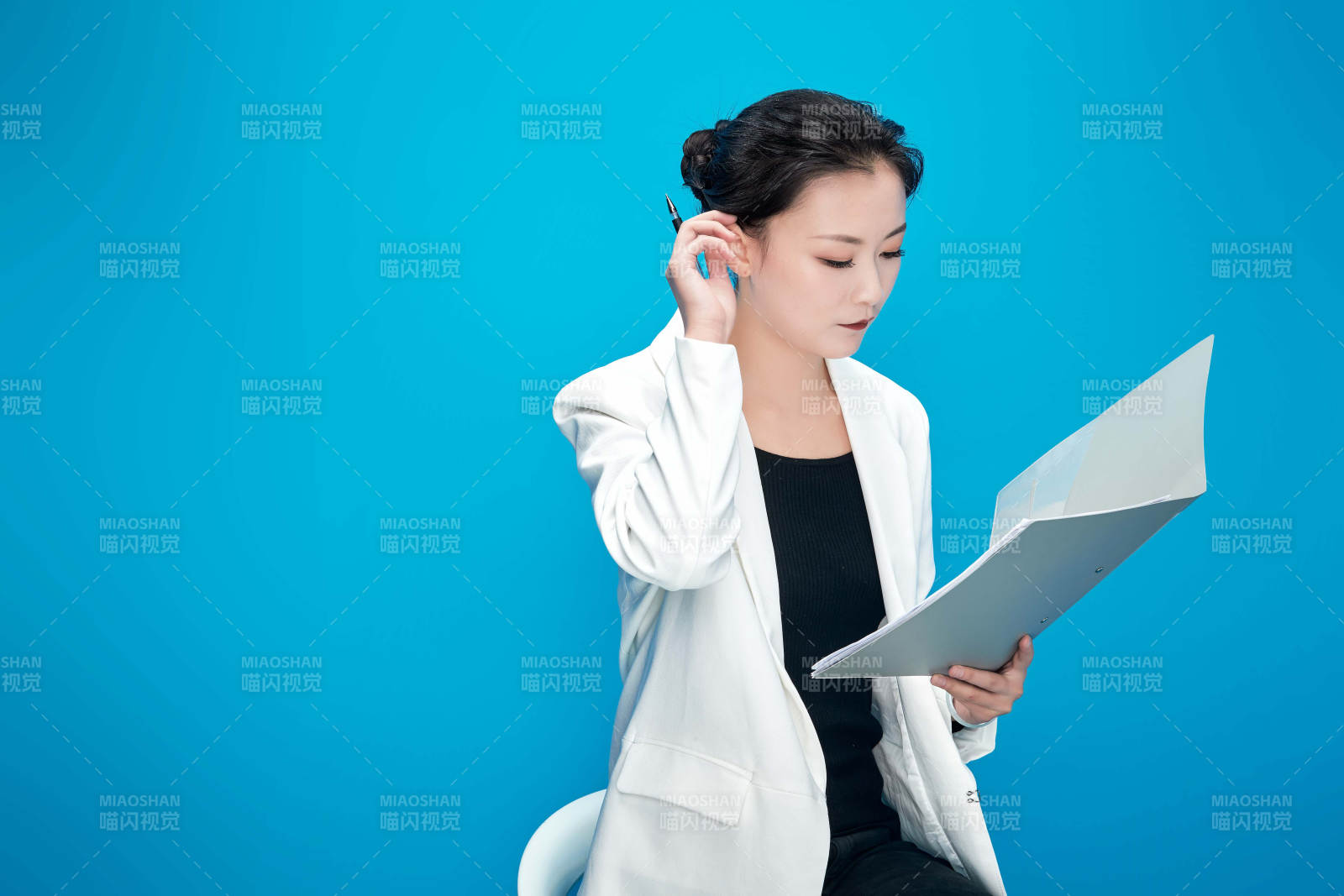 身穿西服拿著手機與文件夾的亞洲商務女士