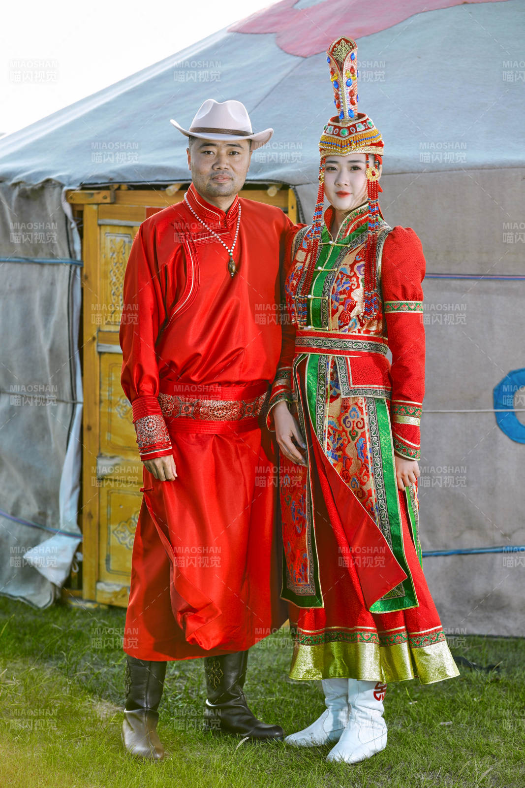 草原上蒙古包前穿蒙古族傳統服飾的年輕夫妻