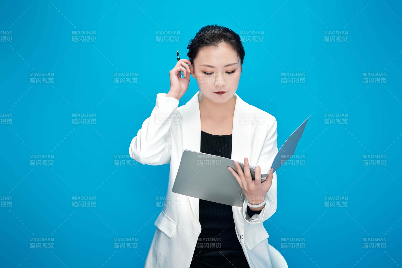 身穿西服拿著手機與文件夾的亞洲商務女士