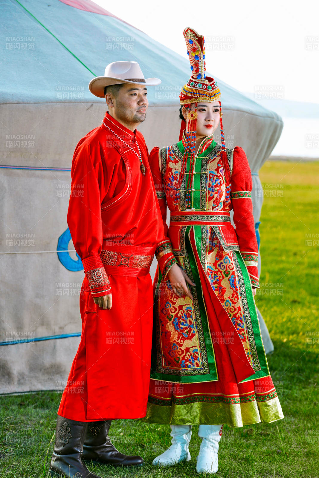 草原上蒙古包前穿蒙古族傳統服飾的年輕夫妻