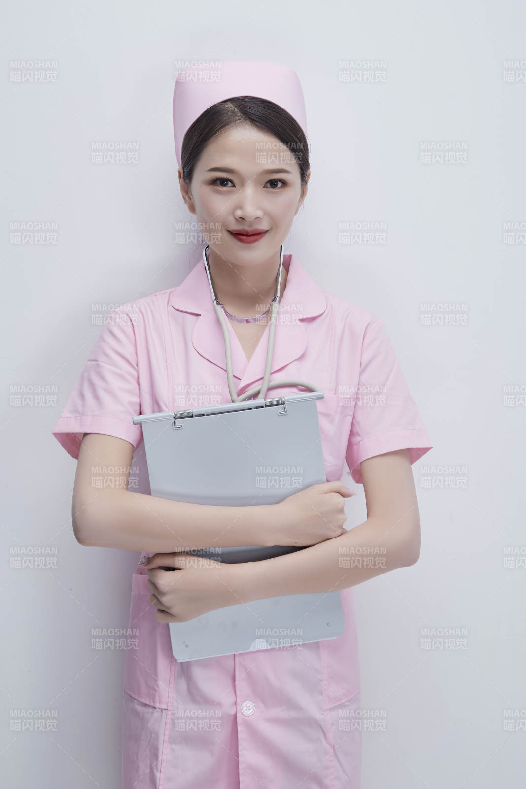 穿粉色護士服戴聽診器手持病歷夾的醫護人員