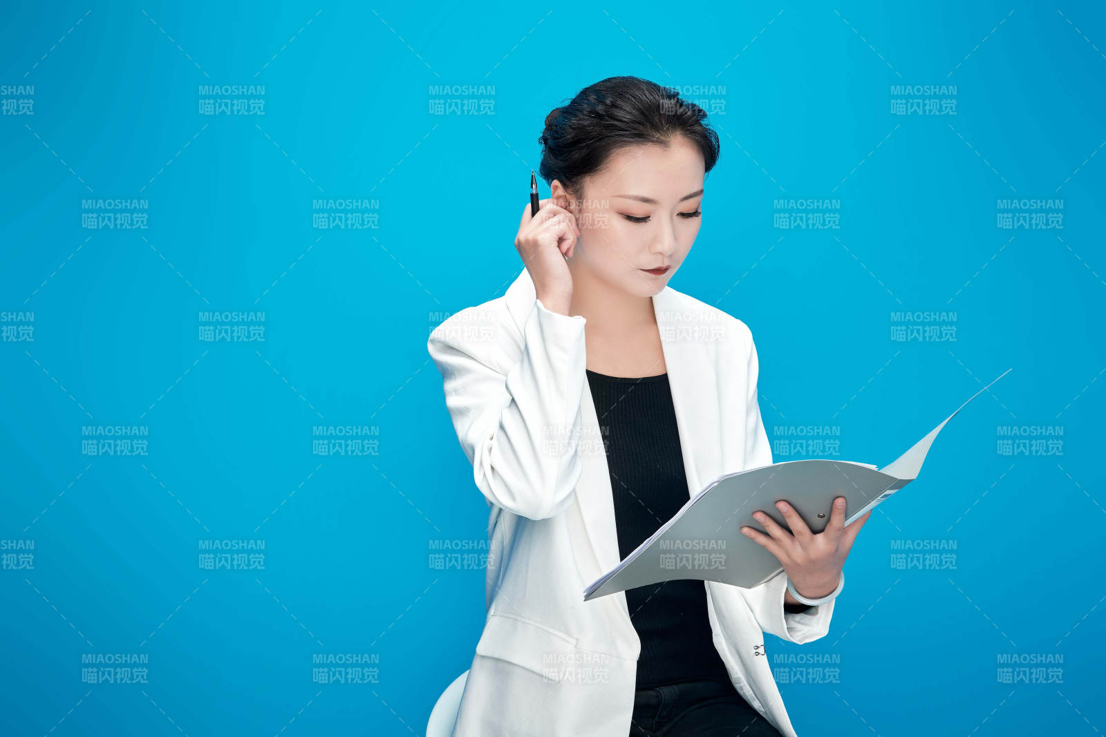 身穿西服拿著手機(jī)與文件夾的亞洲商務(wù)女士