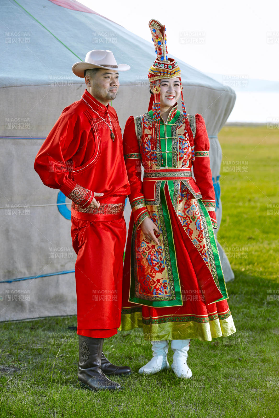 草原上蒙古包前穿蒙古族傳統服飾的年輕夫妻