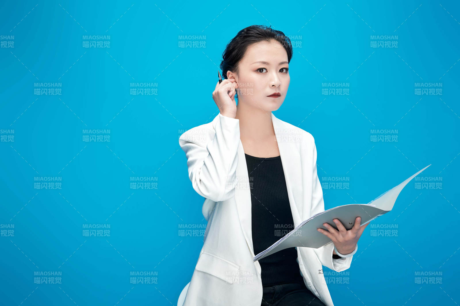 身穿西服拿著手機與文件夾的亞洲商務女士