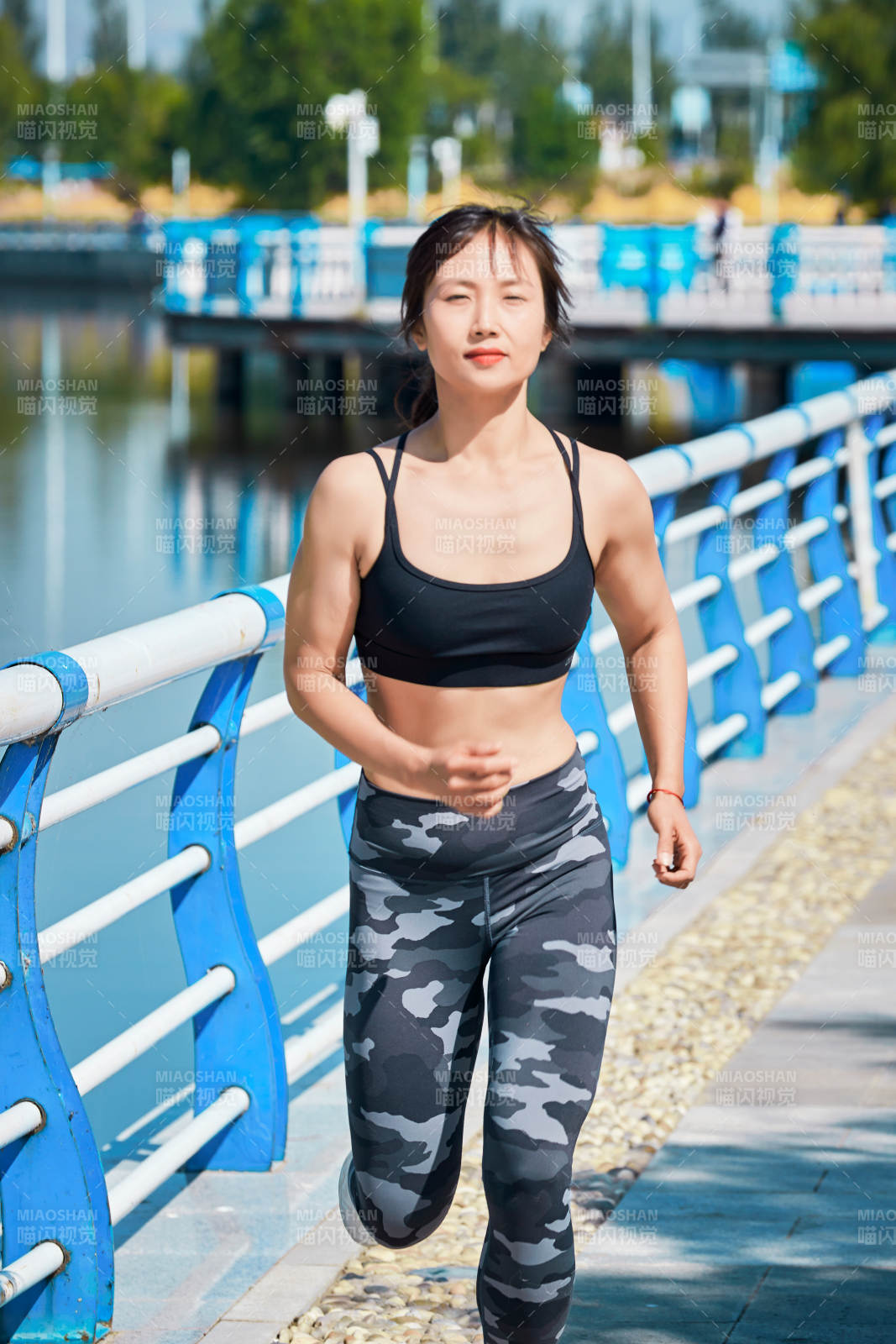 戶外河畔公園做拉伸有氧運動的亞洲女性