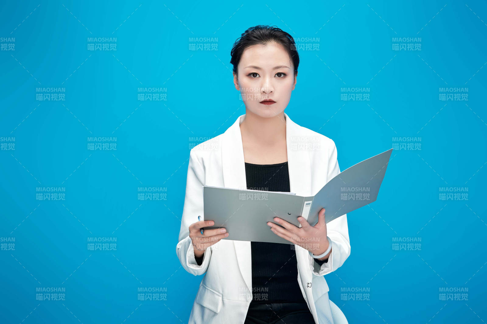 身穿西服拿著手機與文件夾的亞洲商務女士