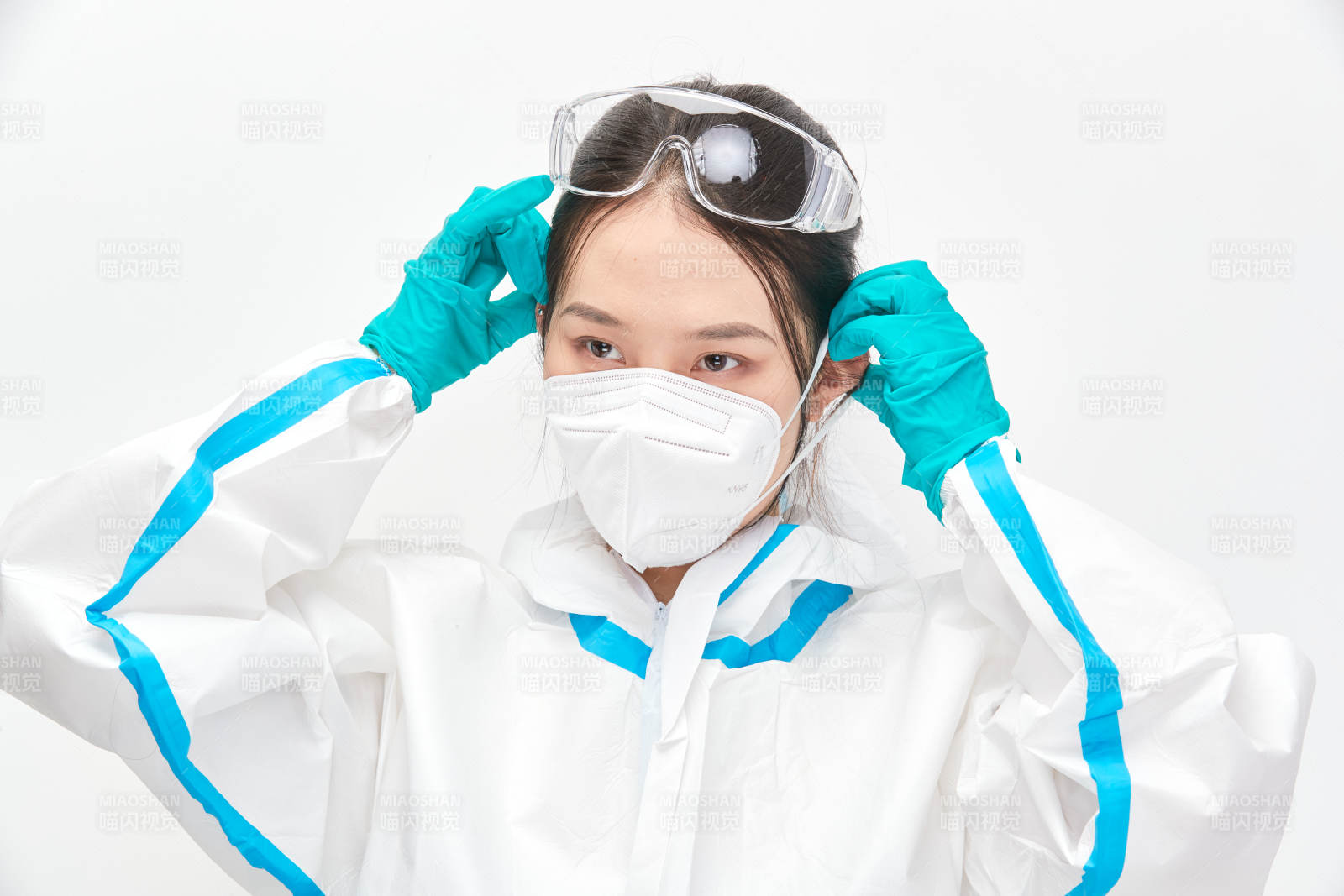 穿白色防護(hù)服佩戴護(hù)目鏡口罩的女性醫(yī)療人員