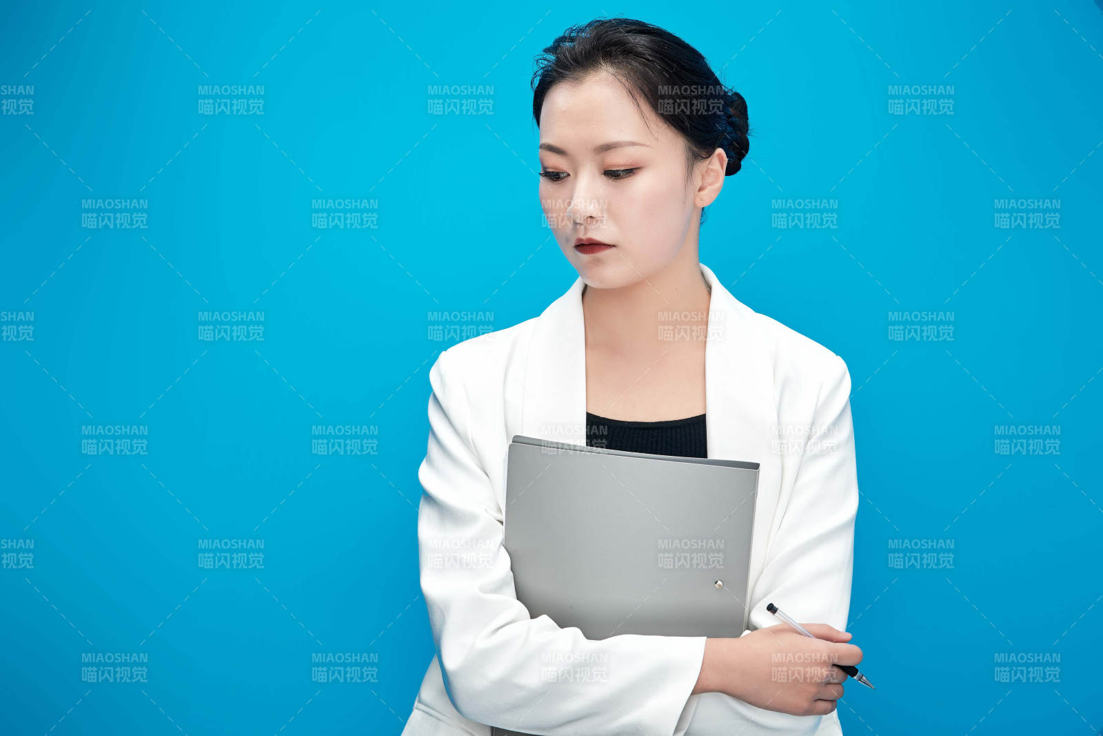 身穿西服拿著手機與文件夾的亞洲商務女士