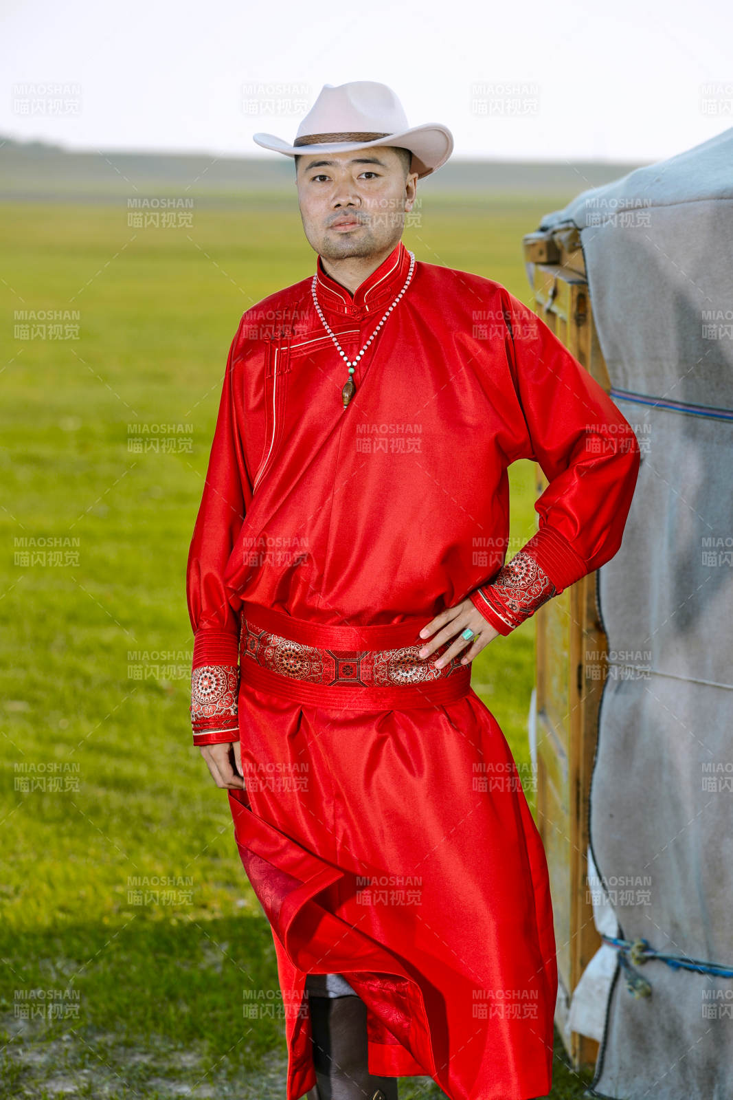 草原上蒙古包前身穿蒙古族傳統(tǒng)服飾的男子