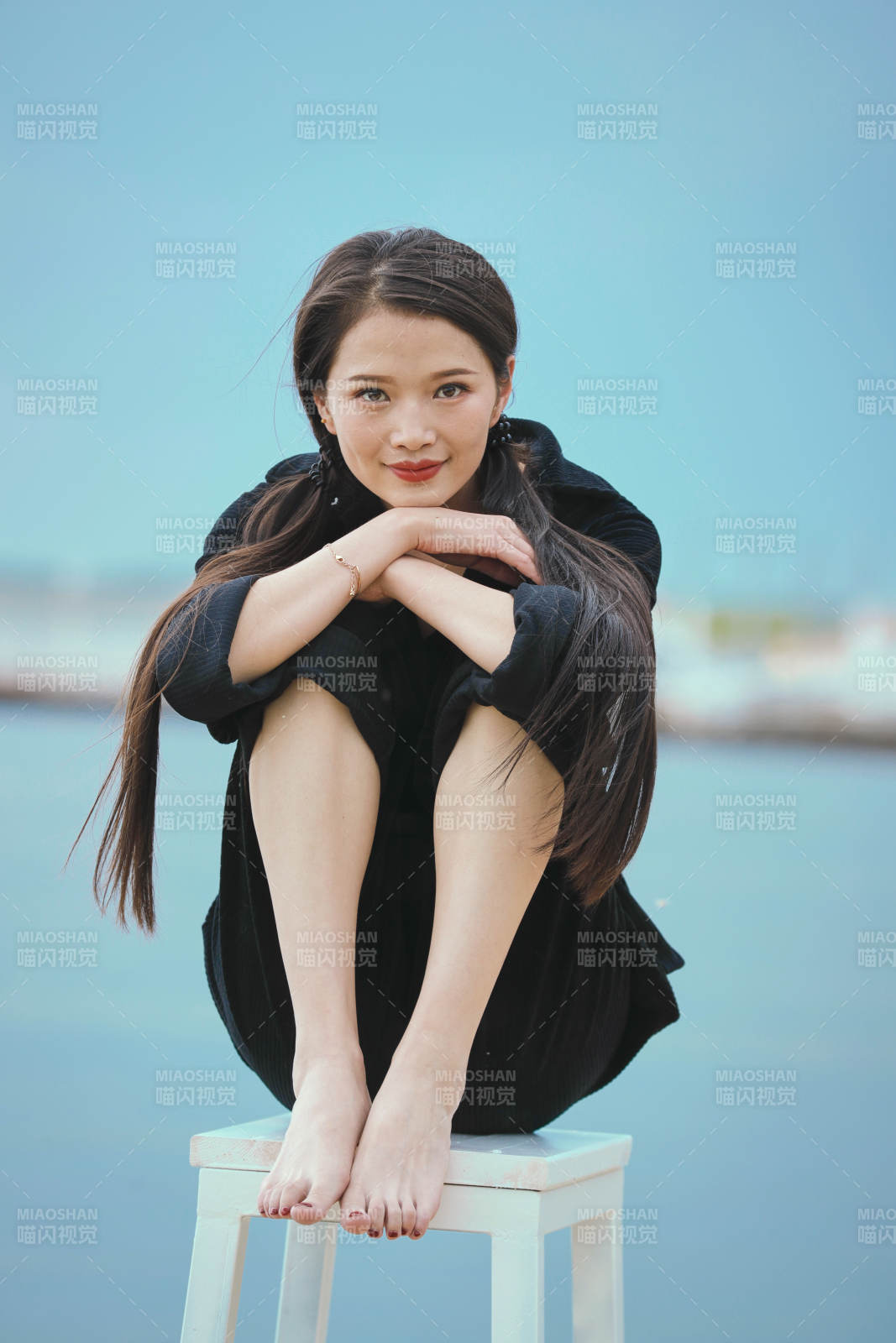 悠閑的坐在美麗湖岸碼頭的亞洲年輕女性人像